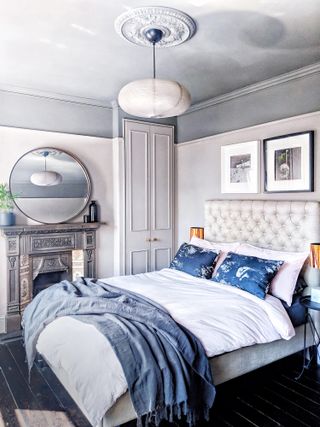 Alcove ideas: A grey bedroom with panelled wardrobes, two-toned walls, original Victorian floorboards and a Victorian-style fireplace