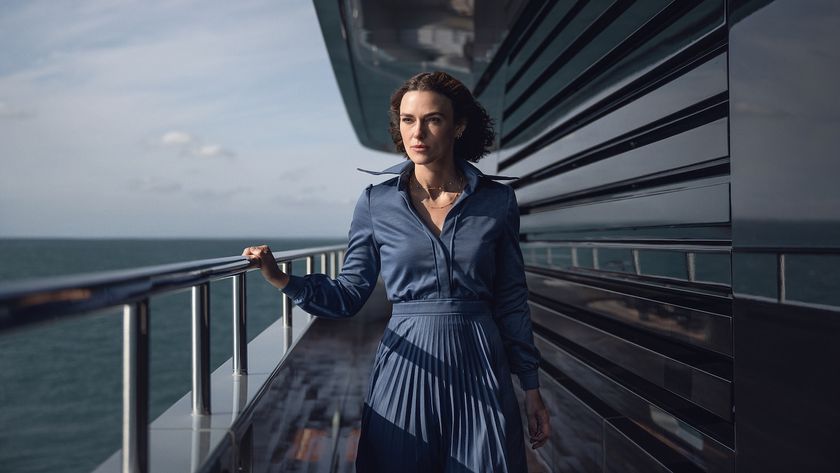 Keira Knightley walking on a yacht in a blue pleated dress 