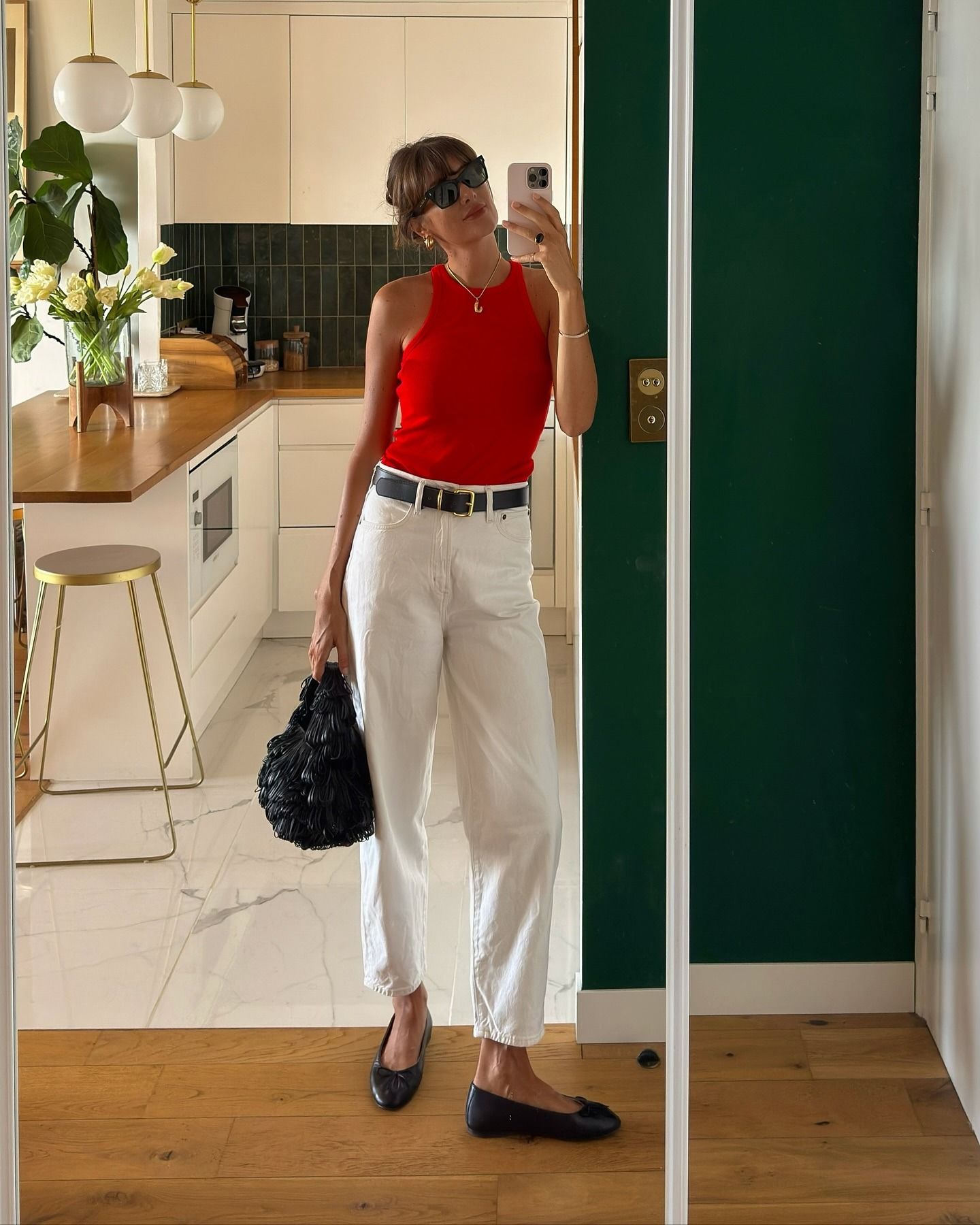 French influencer wearing a red tank and cream jeans
