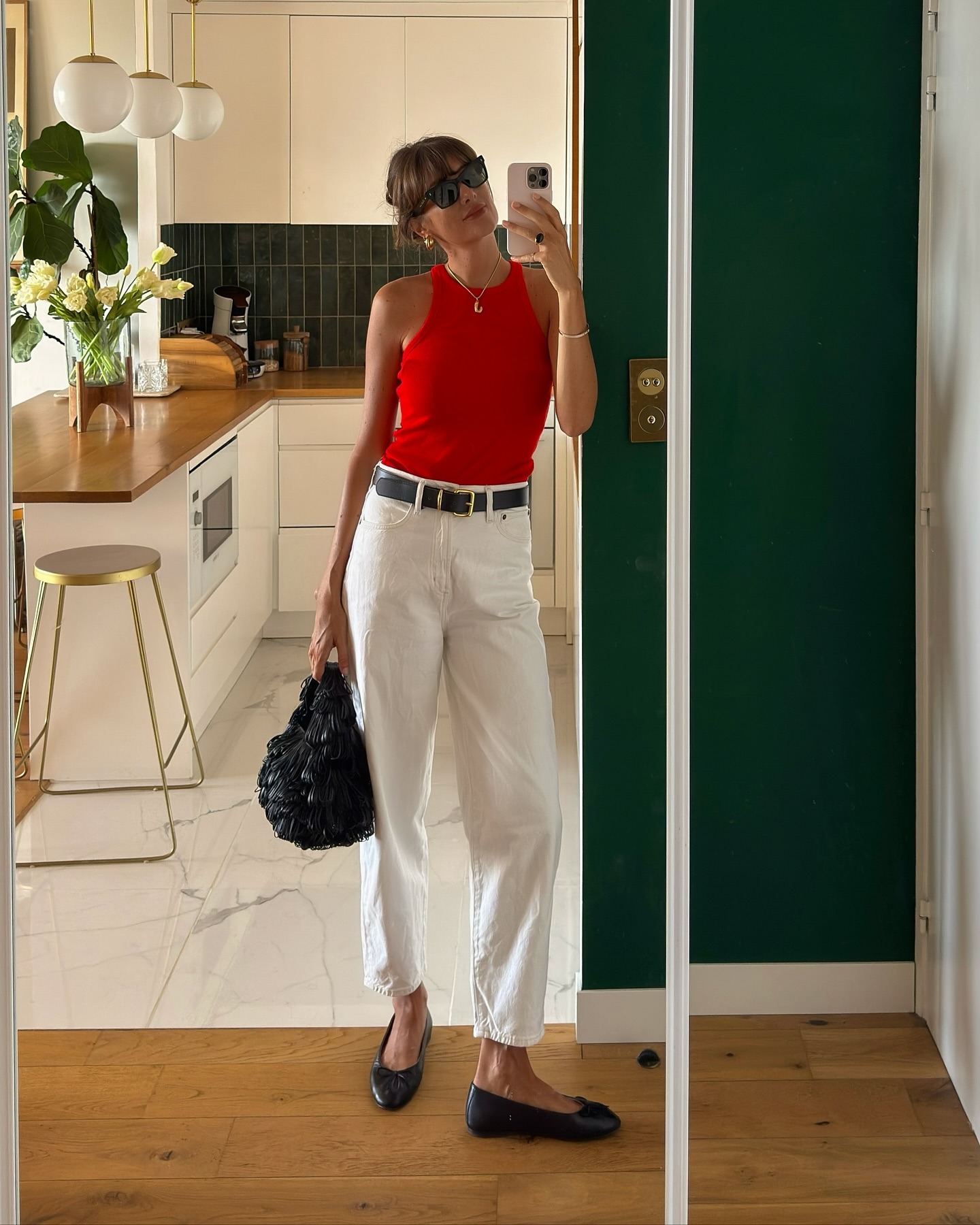 French influencer wearing a red tank and cream jeans