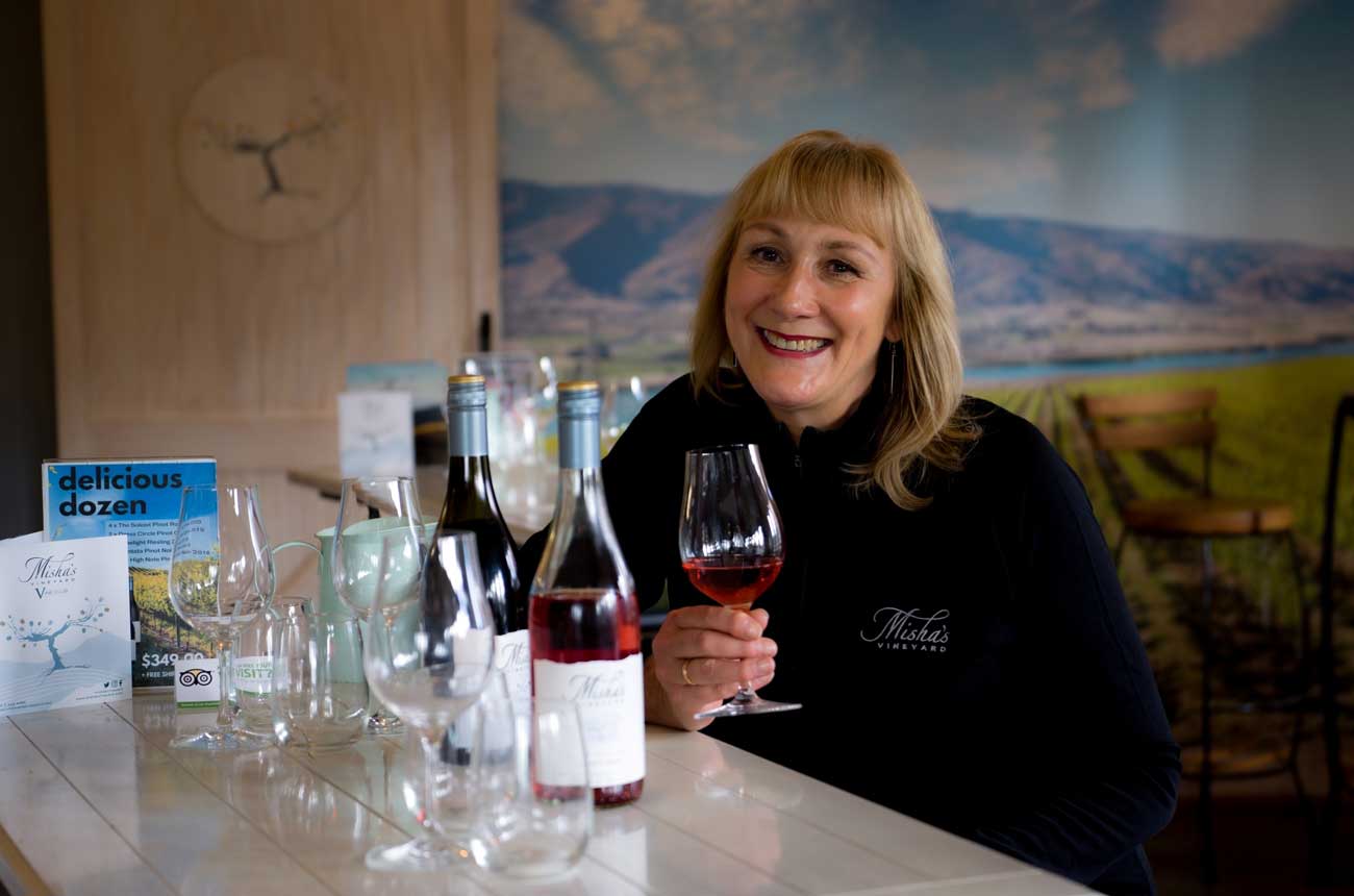 Misha Wilkinson holds a glass of wine in the tasting room
