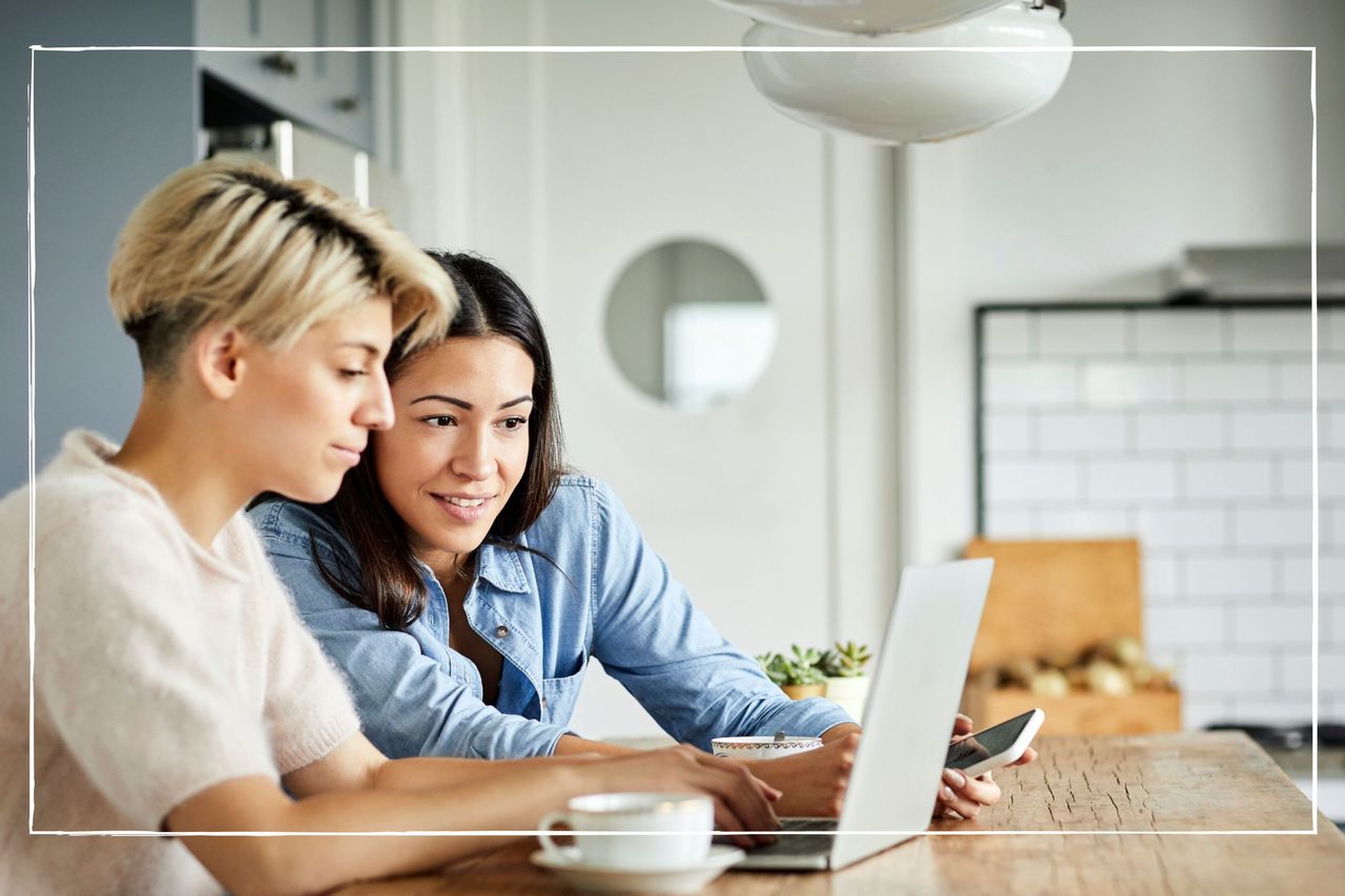 couple looking at laptop on counter at home