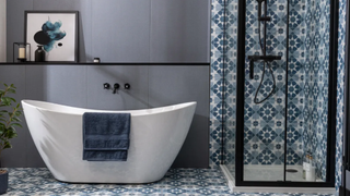 Bathroom with freestanding tub and blue patterned tiles which go on the floor and into the shower enclosure