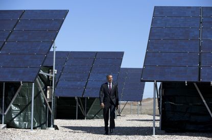 The president walking through a solar array in April.