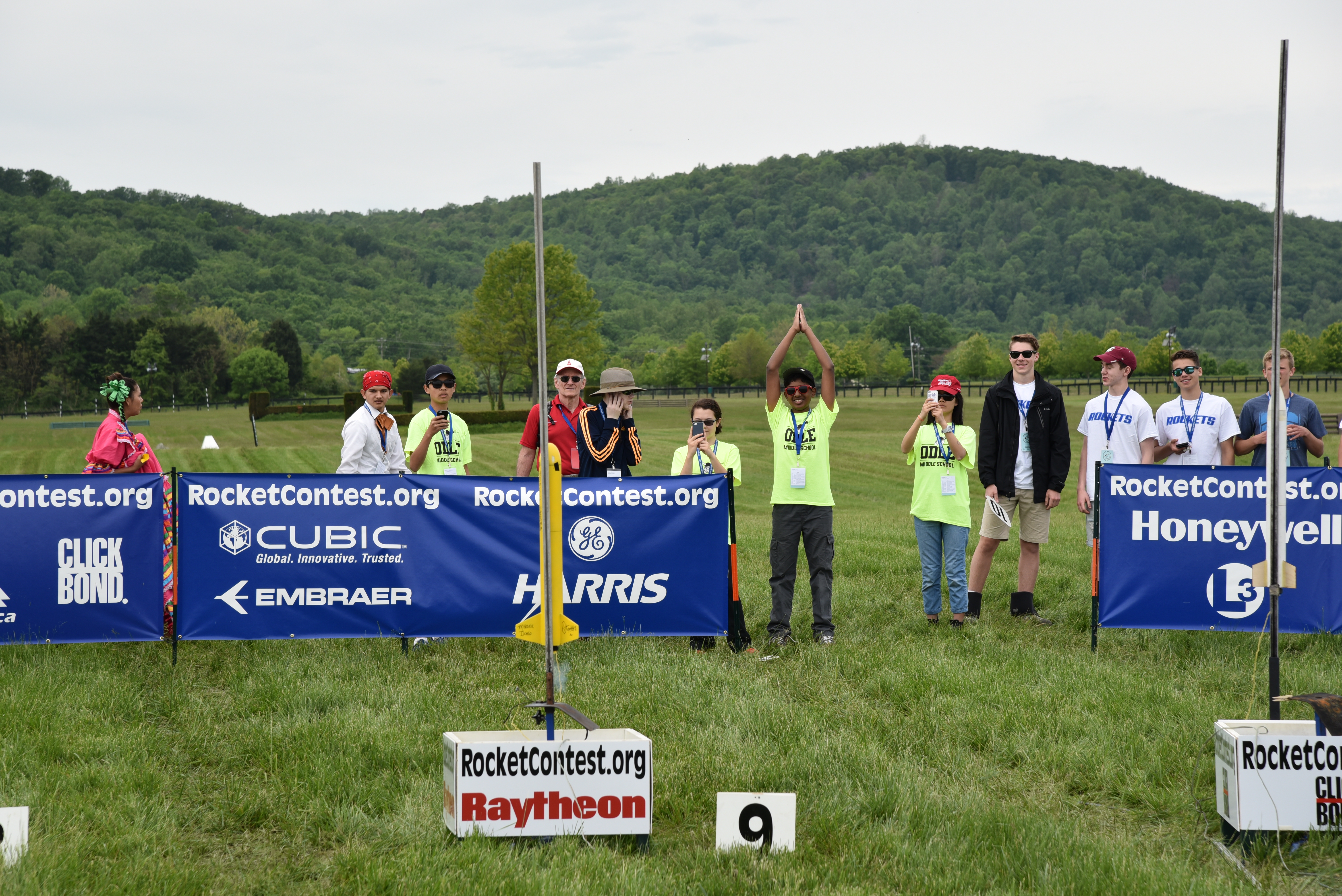 Kids gather around launching model rocket outside