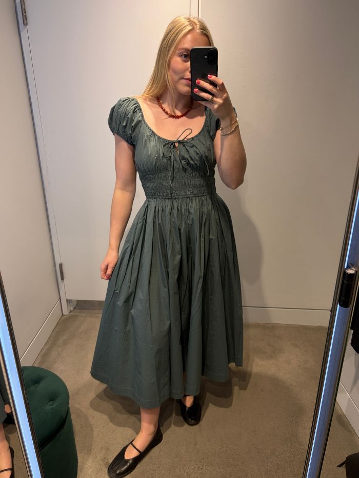 Woman wears Doen Quinn dress in green with black ballet flats