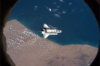 Space shuttle Discovery floats over southern Morocco during the ISS fly-around before departing to return to Earth.