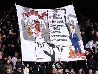 Crystal Palace fans hold up a banner criticising the new ownership of Newcastle