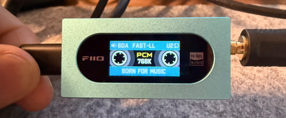 A photo of the front of the FiiO KA15 portable DAC showing its fun cassette-like interface
