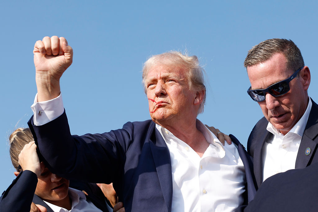 BUTLER, PENNSYLVANIA - JULY 13: Republican presidential candidate former President Donald Trump is rushed offstage by U.S. Secret Service agents after being grazed by a bullet during a rally on July 13, 2024 in Butler, Pennsylvania. Butler County district attorney Richard Goldinger said the shooter is dead after injuring former U.S. President Donald Trump, killing one audience member and injuring another in the shooting. (Photo by Anna Moneymaker/Getty Images)