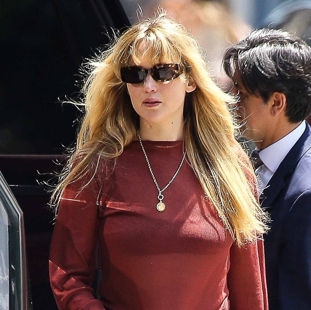 Jennifer Lawrence wearing a red top and sunglasses