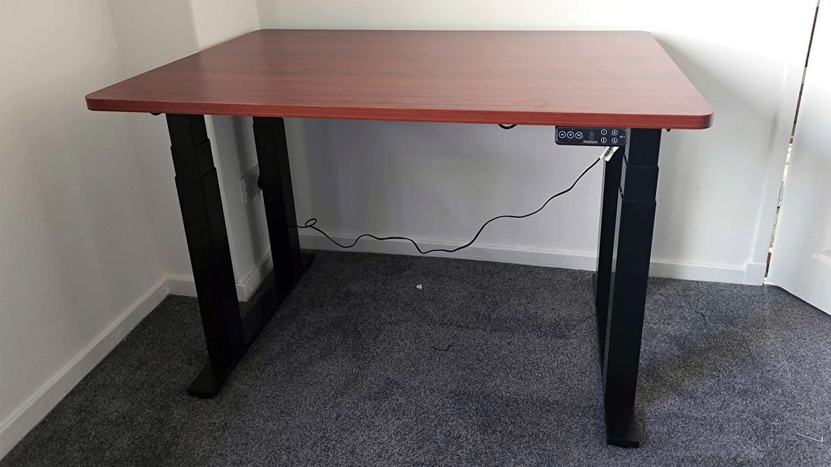 Flexispot E7 Plus assembled sitting on grey carpet with cable connected to power outlet