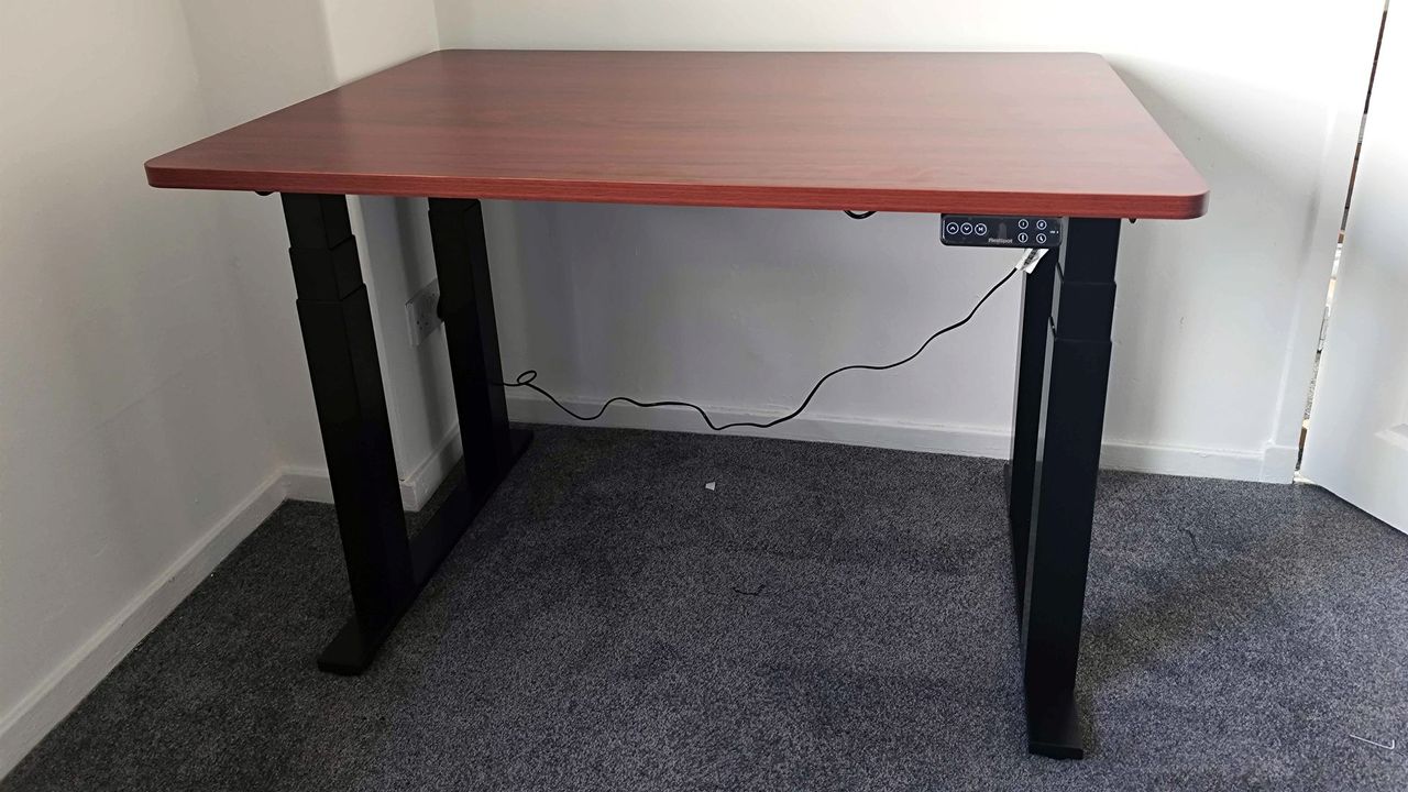 Flexispot E7 Plus assembled sitting on grey carpet with cable connected to power outlet