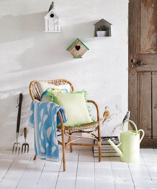 Small porch ideas by Homesense with rattan chair, blankets and birdhouses