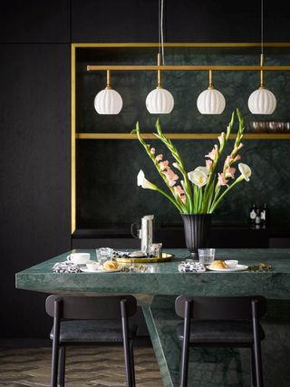 dark dining room with fluted linear pendant lighting by Pooky