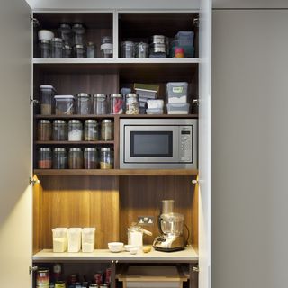 kitchen with grey walls and microwave with cupboard