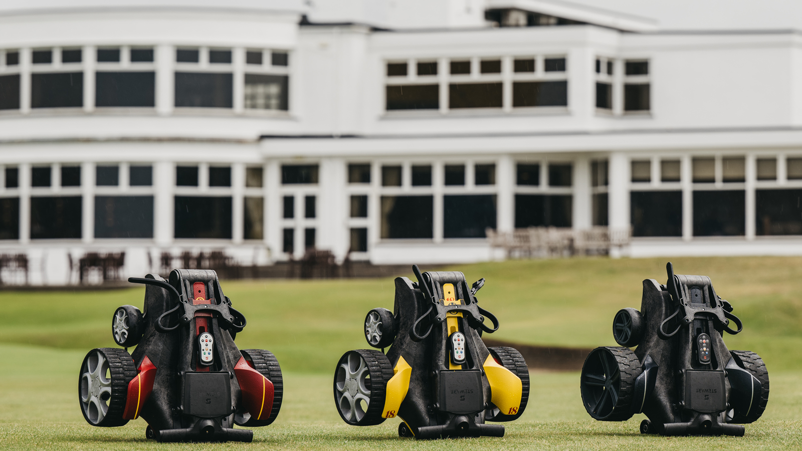 A close-up of three Stewart Golf trollies