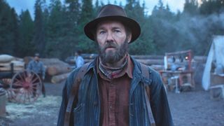 Joel Edgerton stands in a lumberjack's workplace