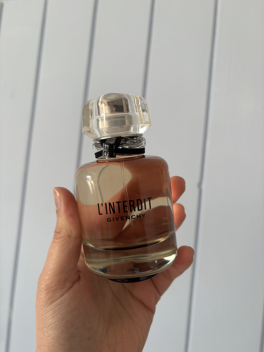 Mica Ricketts holding bottle of Givenchy L'Interdit EDP