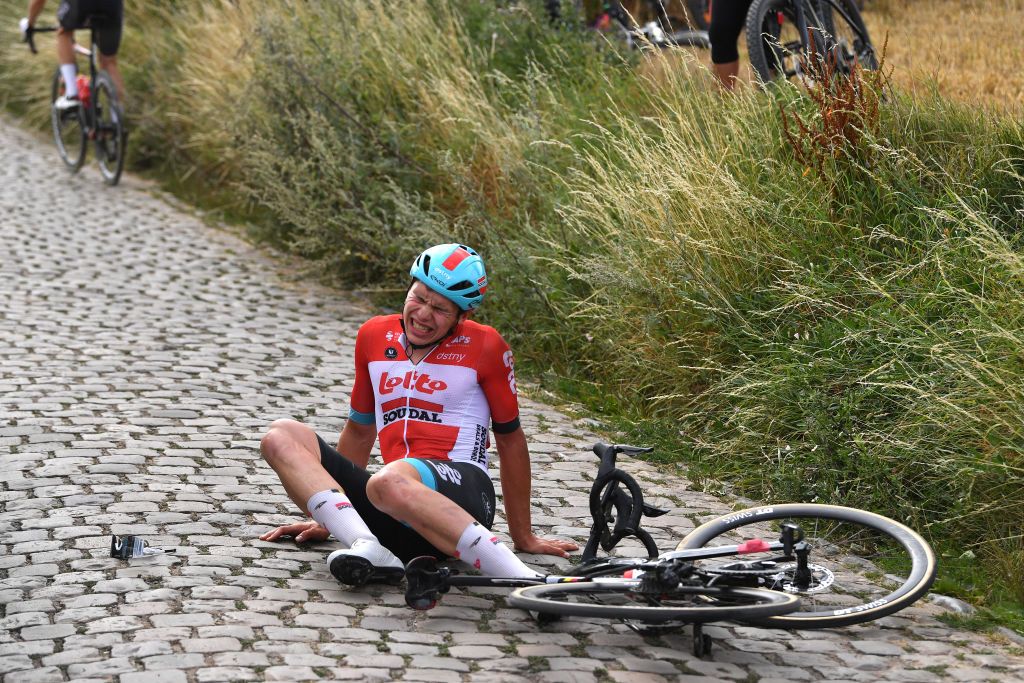 CHAPELLELEZHERLAIMONT BELGIUM JULY 27 Arnaud De Lie of Belgium and Team Lotto Soudal crashes in a cobblestones sector during the 43rd Ethias Tour de Wallonie 2022 Stage 5 a 2148km stage from Le Roeulx to ChapellelezHerlaimont ethiastourdewallonie22 on July 27 2022 in ChapellelezHerlaimont Belgium Photo by Luc ClaessenGetty Images