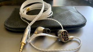 Campfire Audio Solaris Stellar Horizon earbuds and cable on black leather travel pouch, gray background