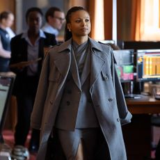 myhala as harper wearing a grey peacoat and suit walking through an office in industry season 4