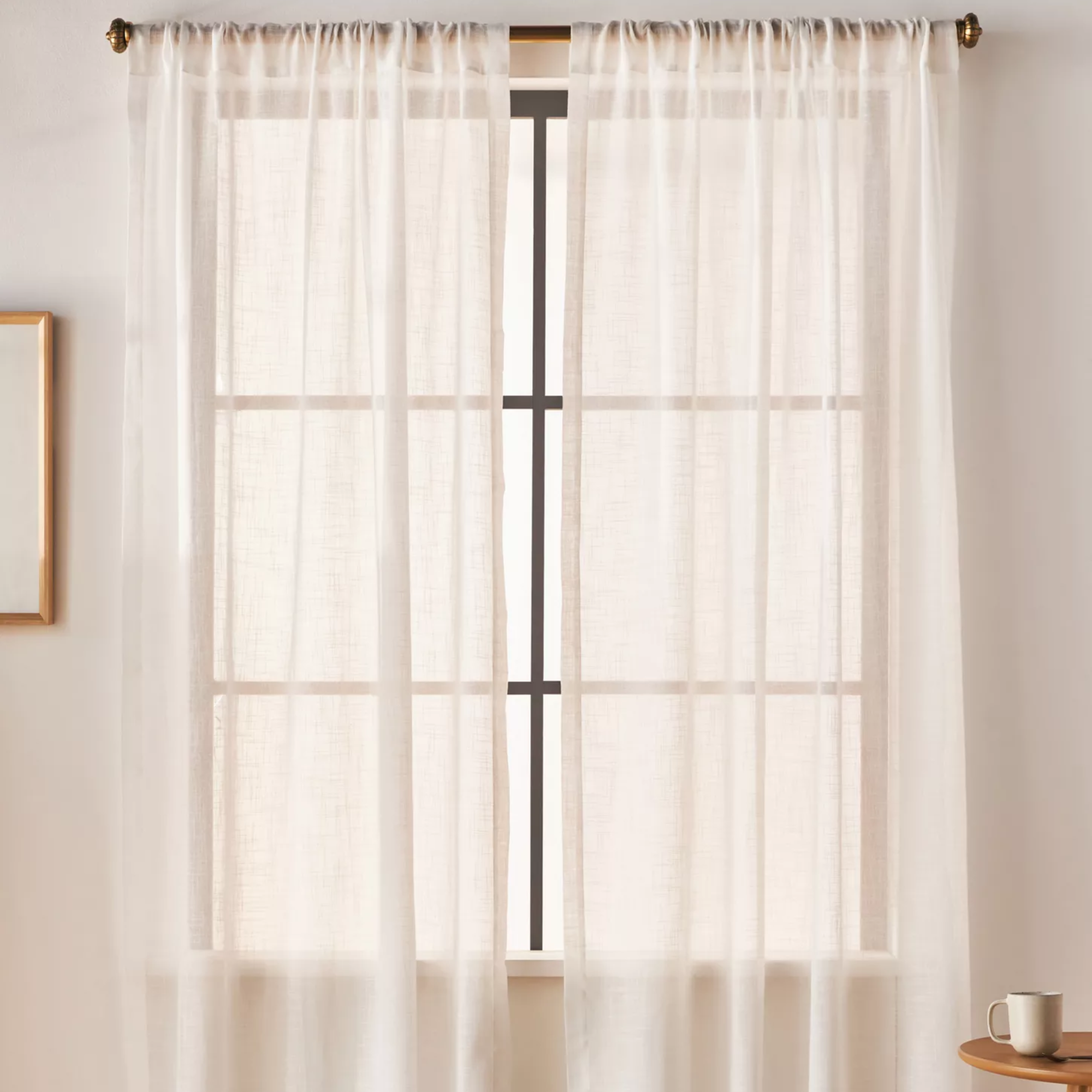 a pair of sheer white curtains blocking a window