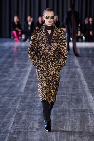 a model wearing a leopard print coat and black pants