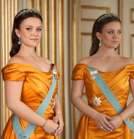 Princess Isabella of Denmark wearing an orange gown looking in a mirror