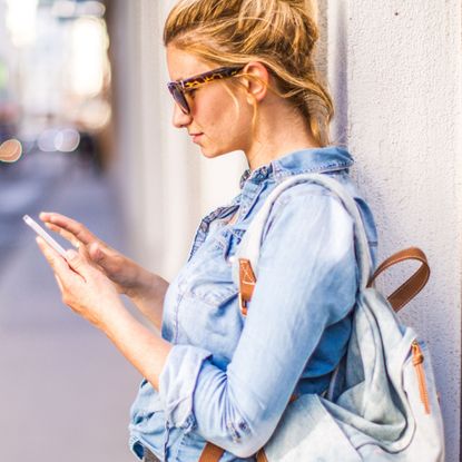 Woman with backpack checking her phone