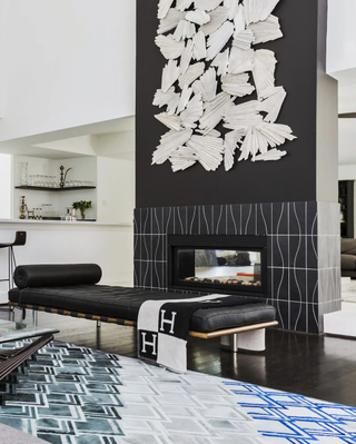 Black and white living room with artwork above a fireplace