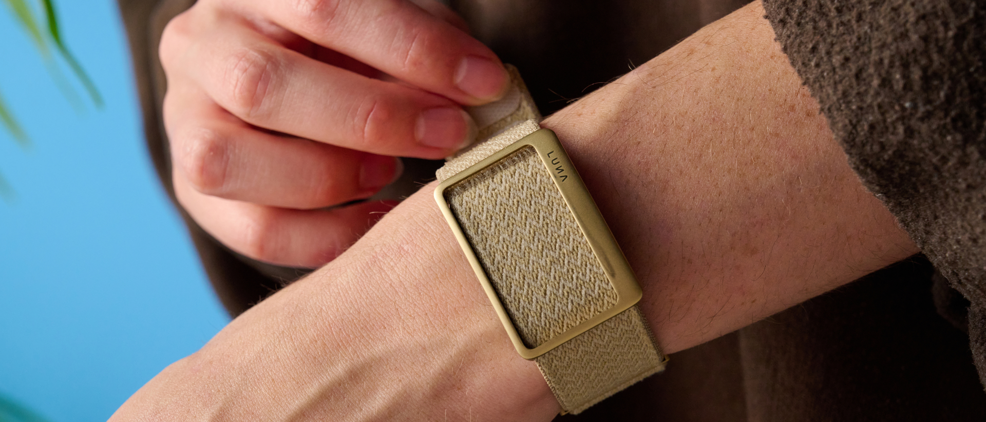 the luna band in beige photographed with the blue tom's guide background being worn by the author