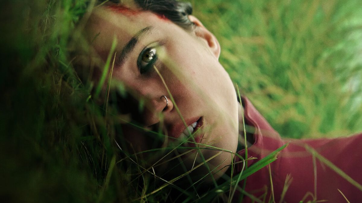 Kelsey Asbille lying on some grass during the upcoming horror movie, Don&#039;t Move.