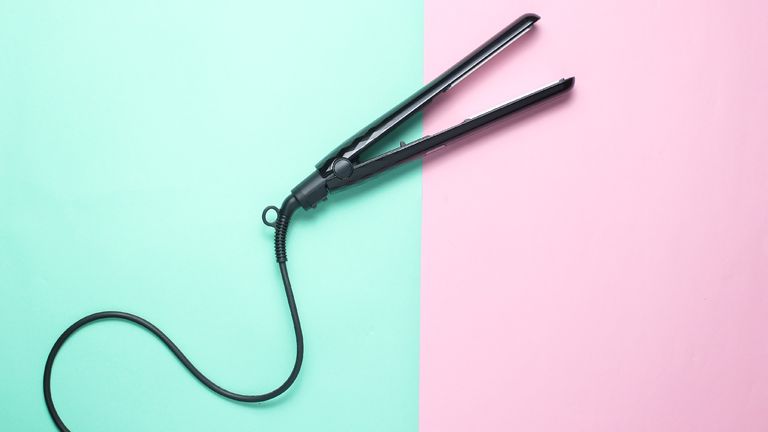 Pair os steam straighteners on a pink and turquoise backdrop