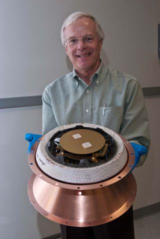 William Ailor, Director of the Center for Orbital and Reentry Debris Studies at The Aerospace Corporation holds a Re-entry Breakup Recorder to record spacecraft re-entry and breakups.