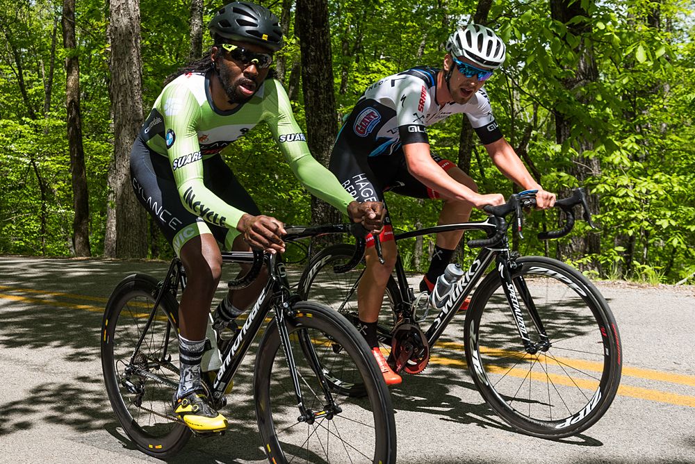 A couple of riders as they both look up the road on a switchback.