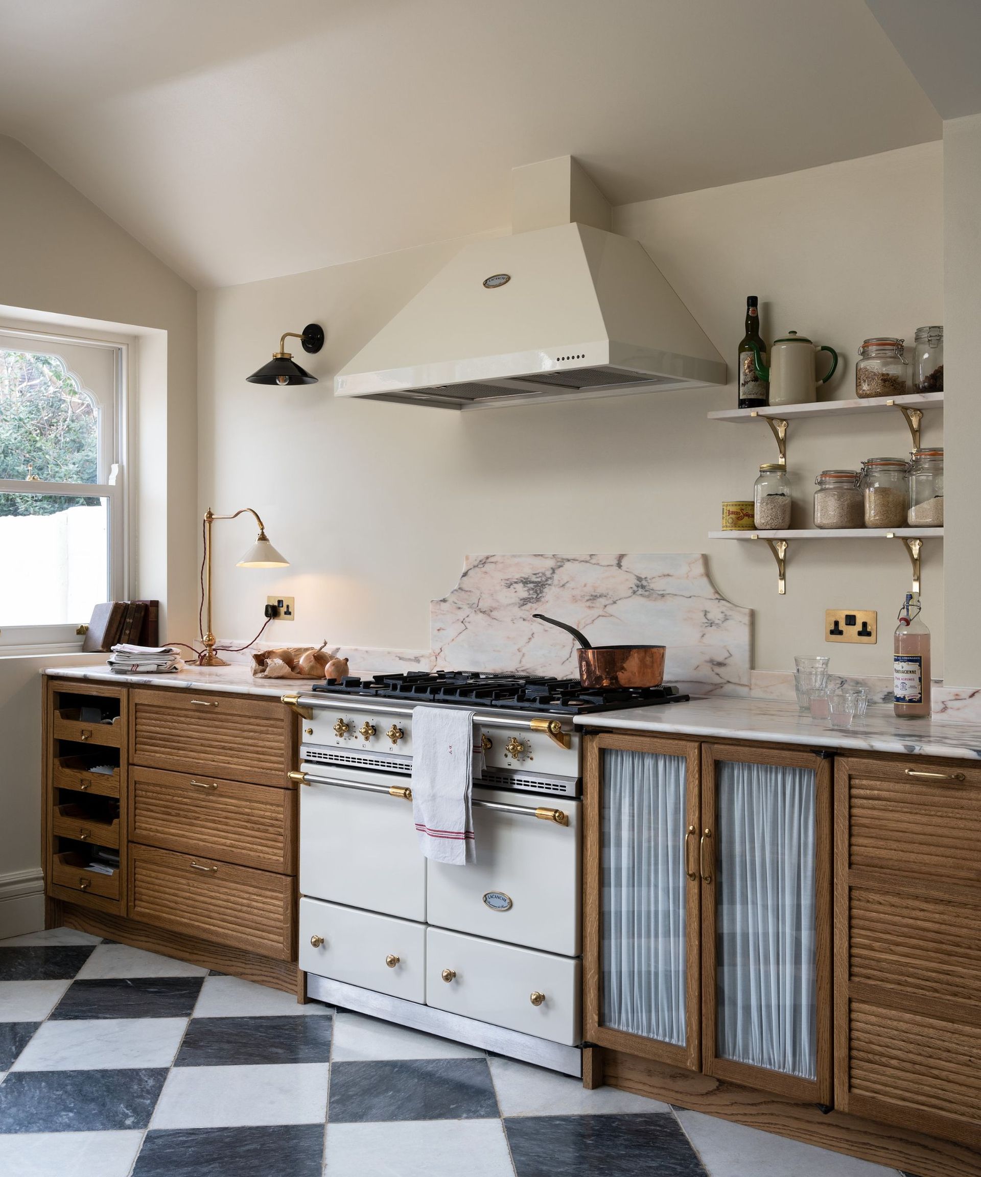A Mid-century style wooden kitchen with checkerboard flooring and marble countertops