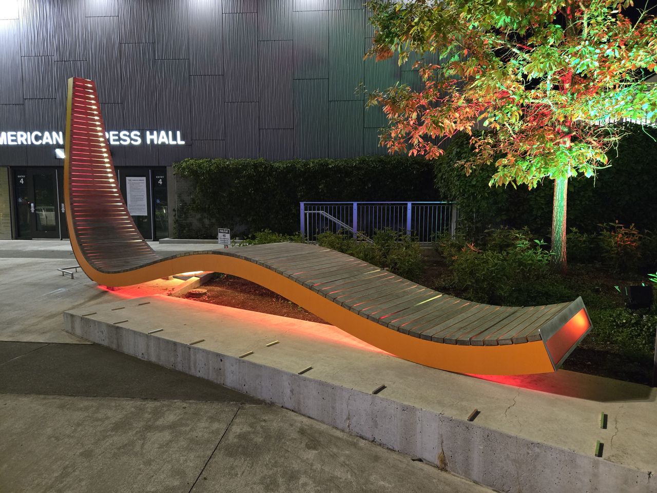 A long orange art installation lit up at night