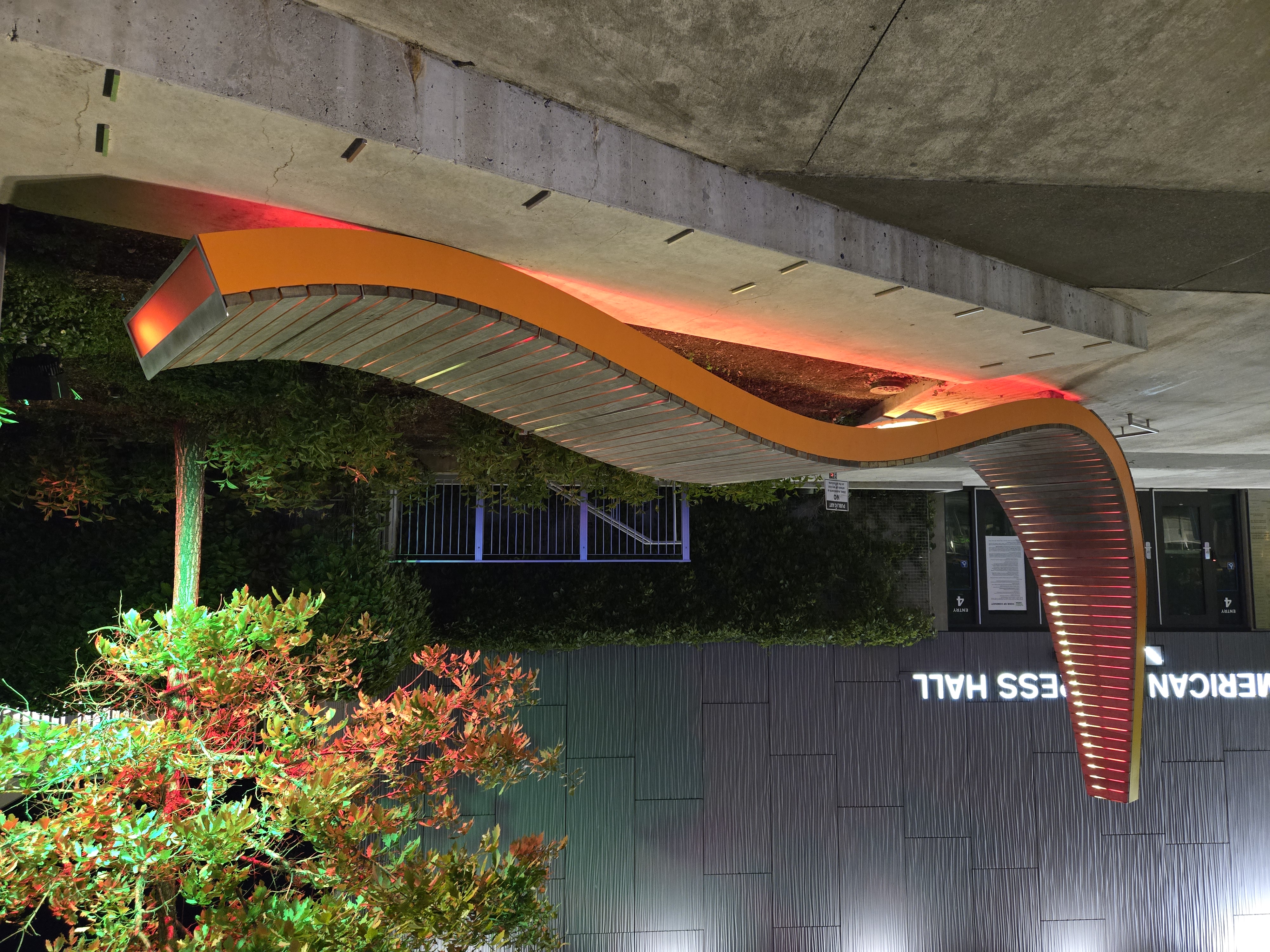 A long orange art installation lit up at night