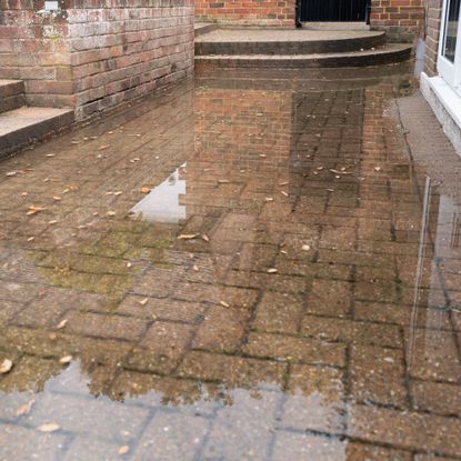 Rainwater accumulating on patio due to a blocked soakaway