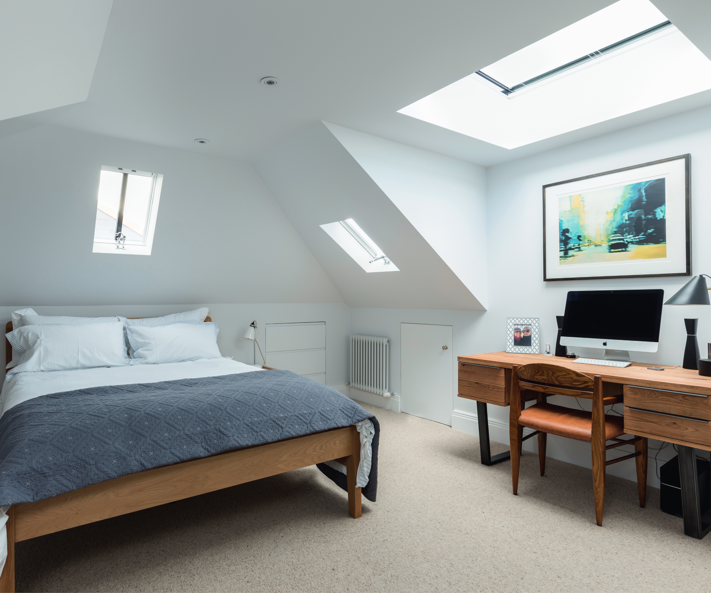 dormer loft bedroom with wooden desk in dormer window area