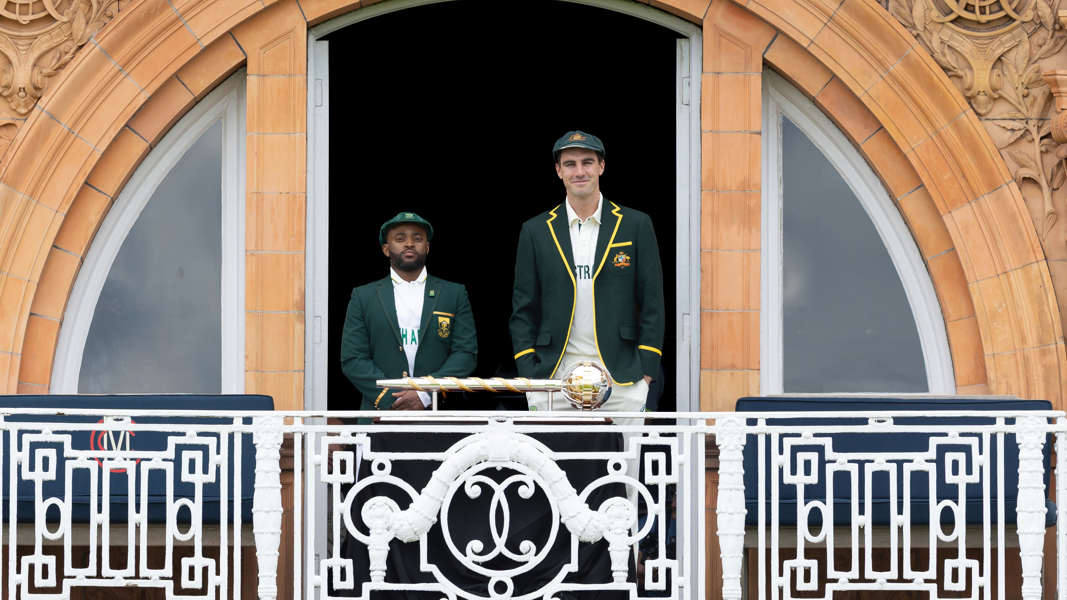 Temba Bavuma and Pat Cummins stand alongside the World Test Championship trophy 2025.