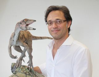 Marcelo Sánchez, a paleontologist at the University of Zurich, holds a model of the dinosaur Laquintasaura venezuelae.