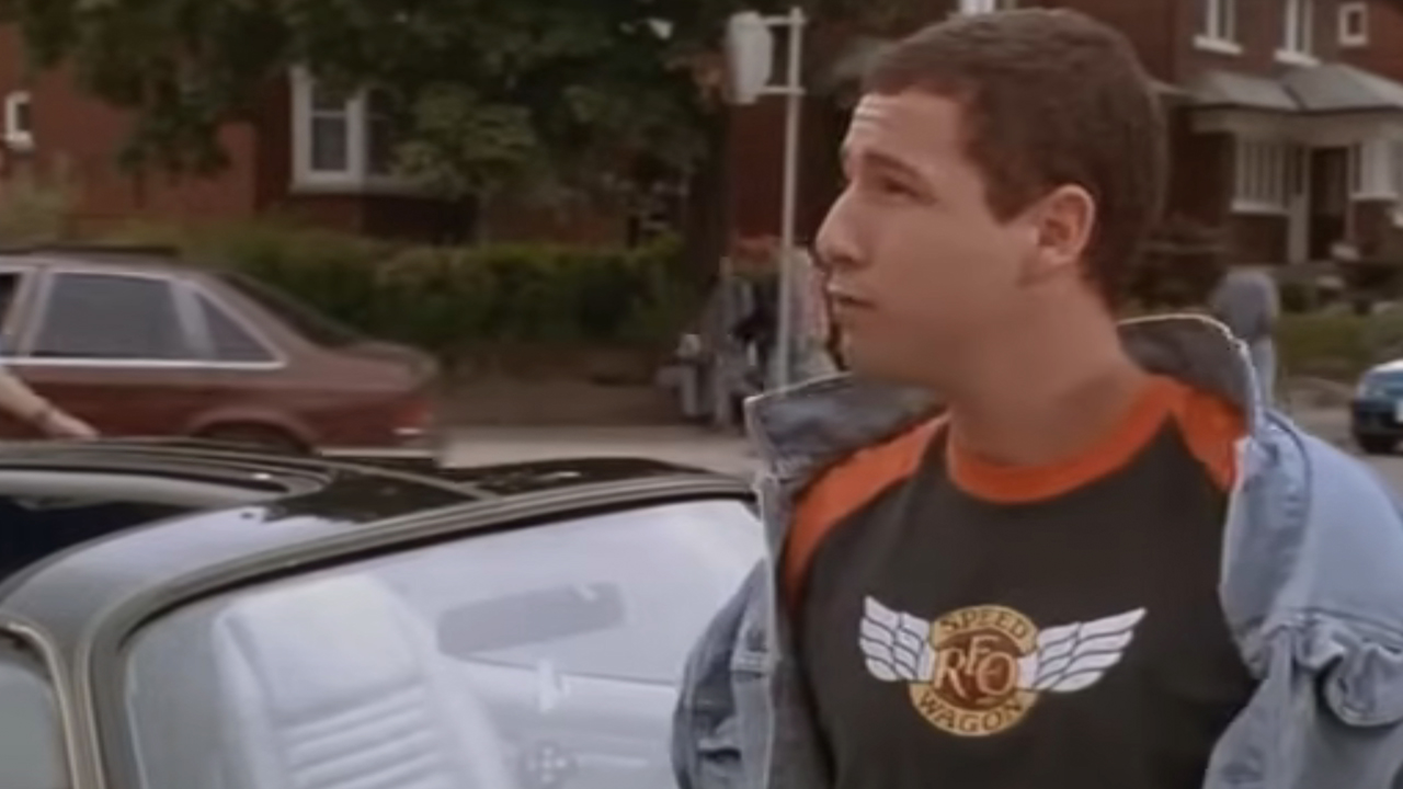 Adam Sandler wearing a jean jacket and a REO Speedwagon tee shirt in Billy Madison