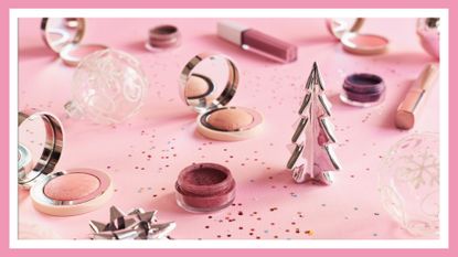 Christmas makeup and decorations on a pink surface, with a white border, to illustrate Christmas makeup on TikTok