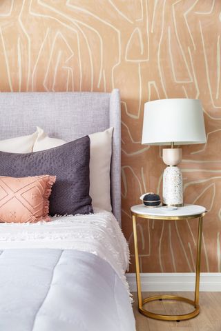 A bedroom with beige wallpaper