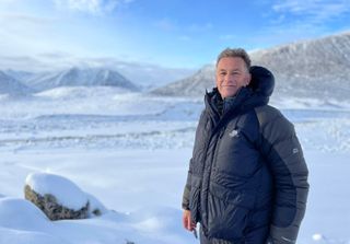 A shot from Our Changing Planet season 2 showing Chris Packham standing in a snowy tundra in Greenland