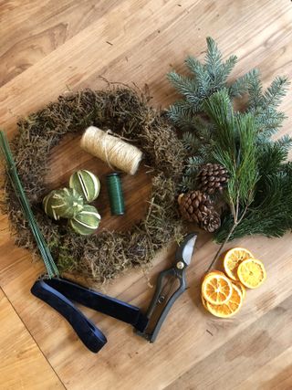 Flat lay of mossed wreath, foliage and dried ingredients to make a Christmas wreath