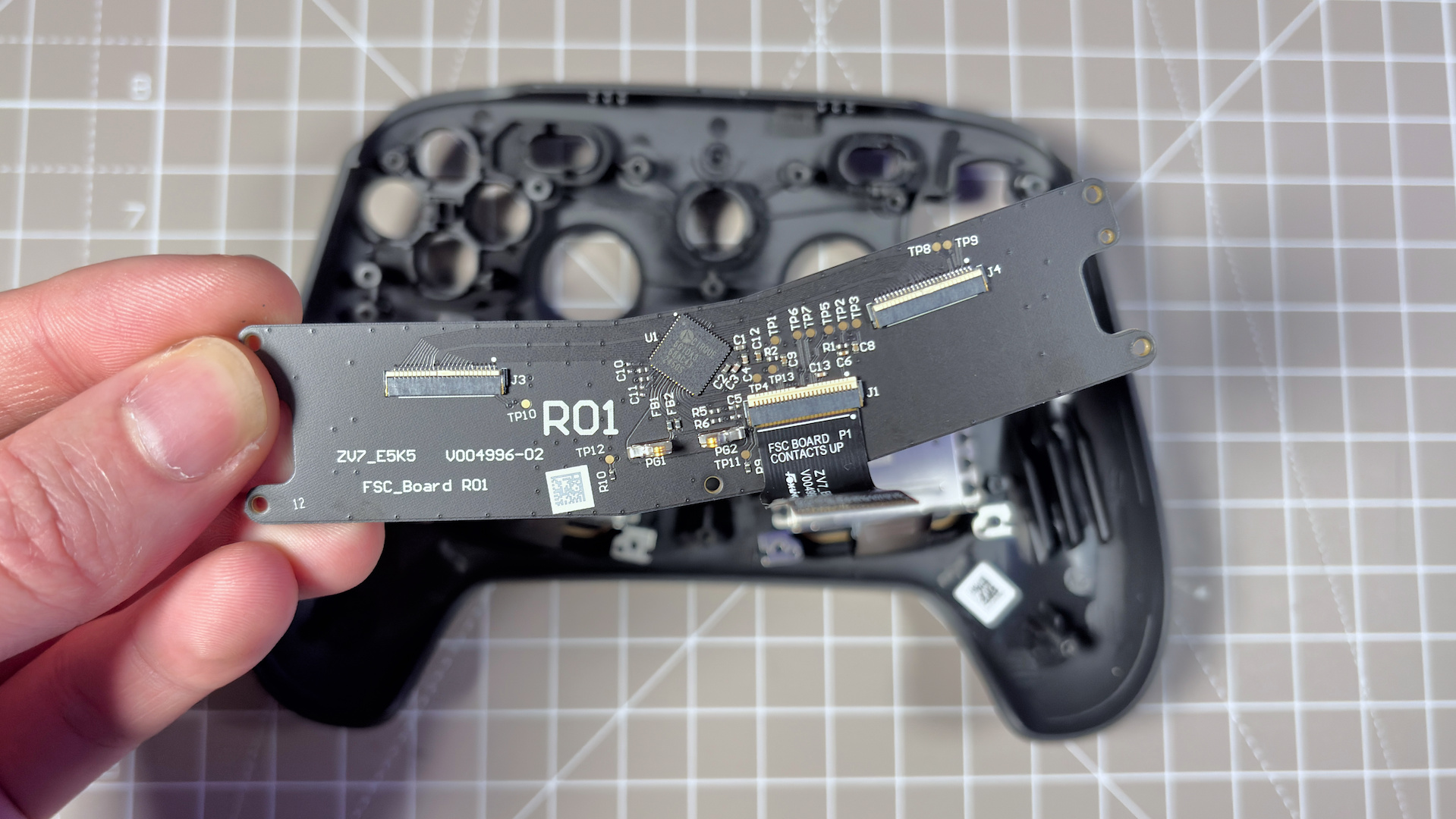 The Steam Controller on a desk during a teardown, with various parts removed.