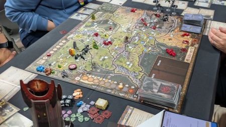 A full setup for Fate of the Fellowship with cards, tokens, and pieces all laid out
